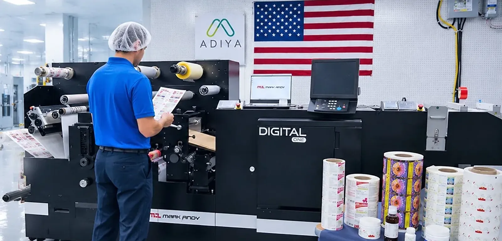 An operator reads a printed sheet at the digital press, with printed label rolls on the table beside it