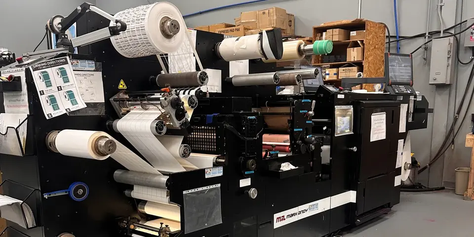 The digital label press, with a roll of printed labels at the unwind