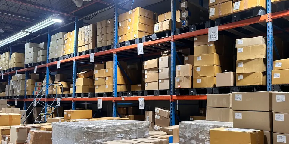 Boxes on pallets in the stock room racking, with zone signs on the beams